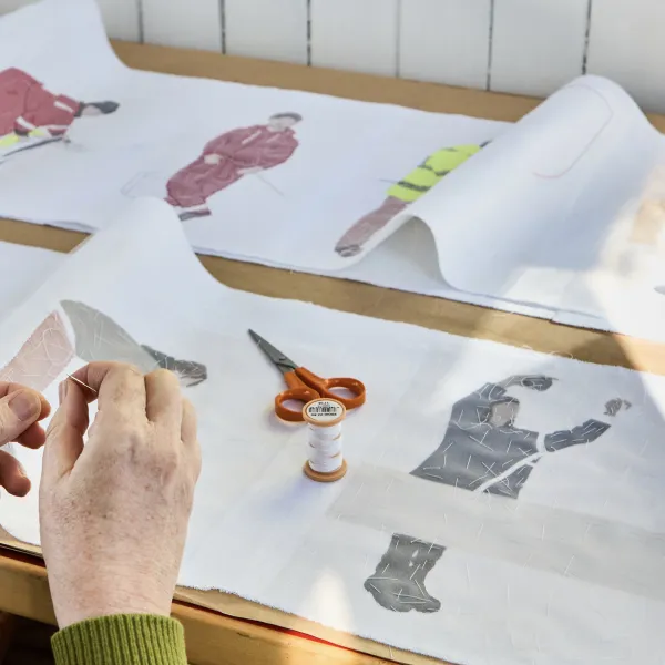 Hands stitching a Procession of Makers